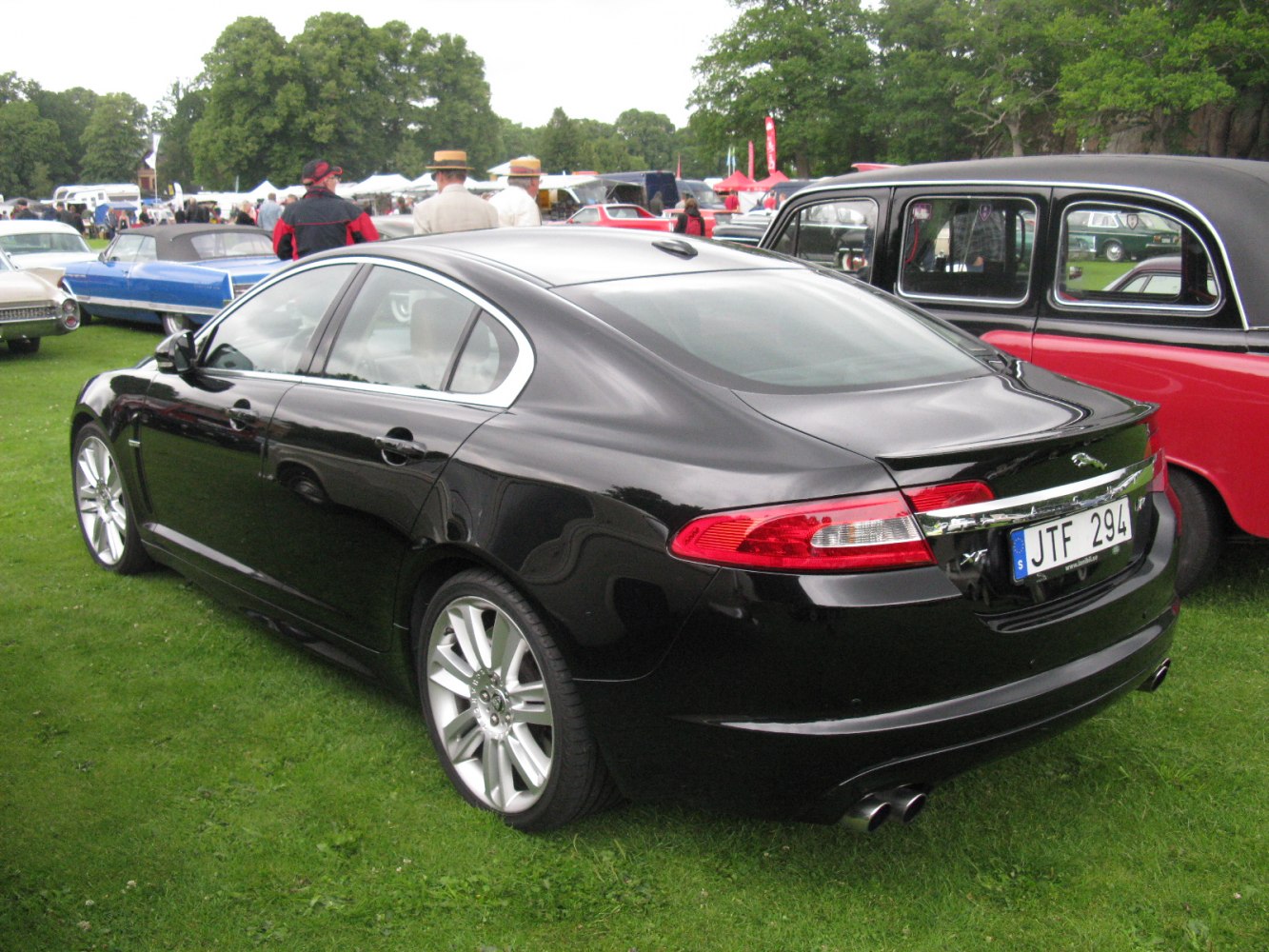 Rear side of a sleek black luxury sedan with dual exhaust and elegant taillights