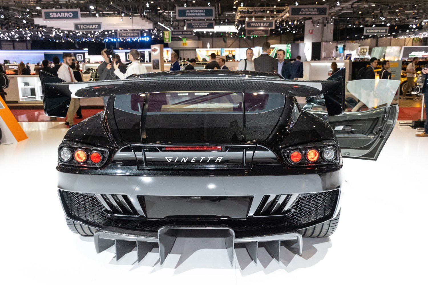 Rear view of sports car with carbon fiber wing spoiler and aggressive diffuser fins