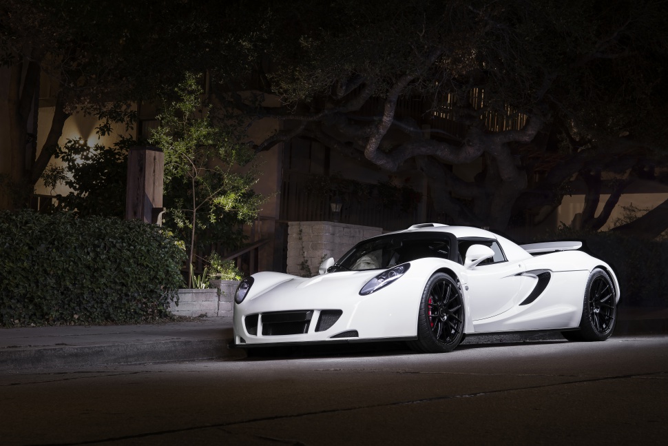 White sports car with aerodynamic design and black wheels at night