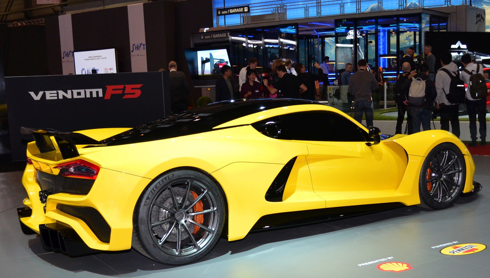 Yellow hypercar rear-side with large spoiler and aerodynamic curves