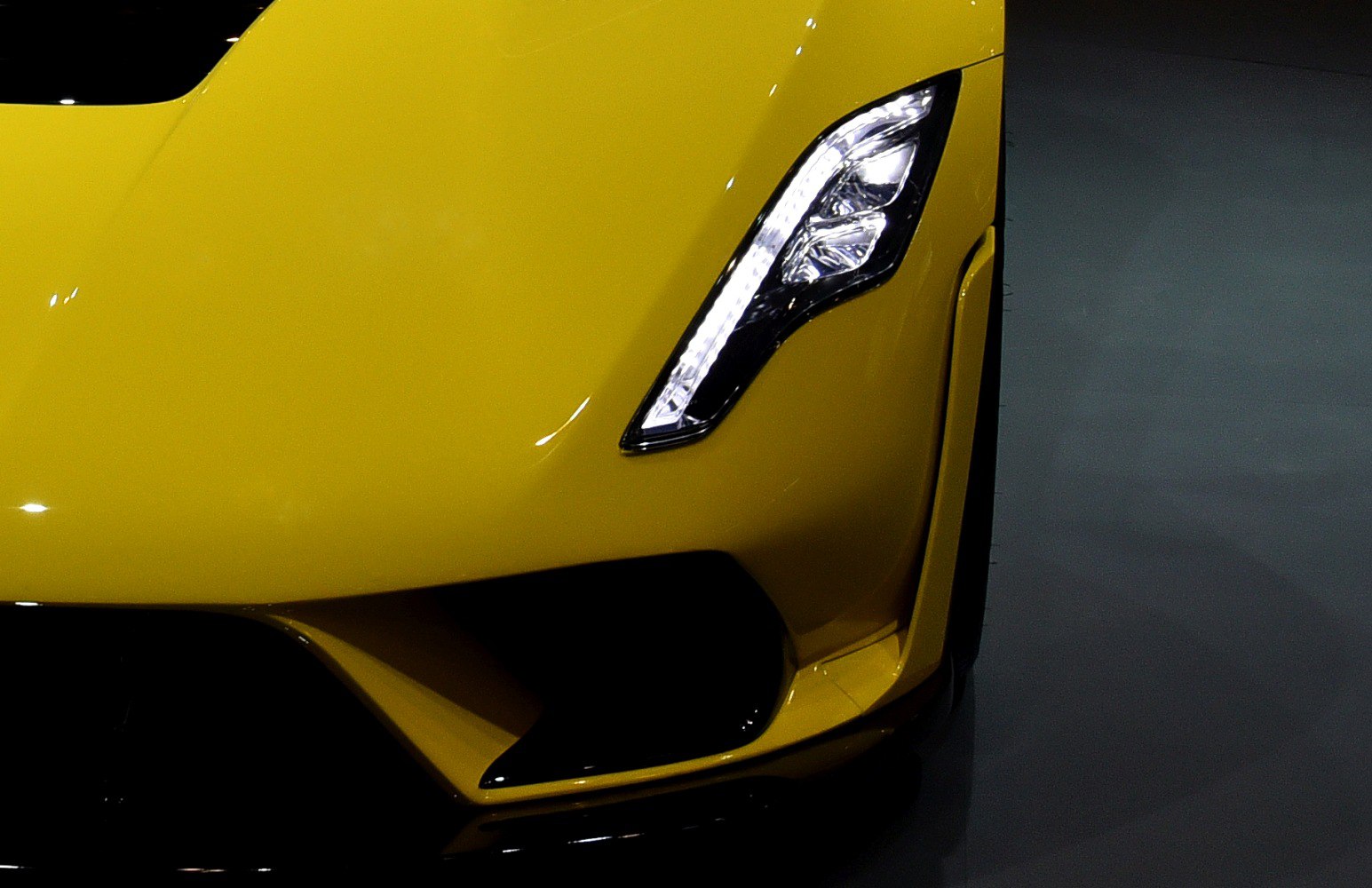 Sharp LED headlight and aerodynamic front vent on yellow vehicle