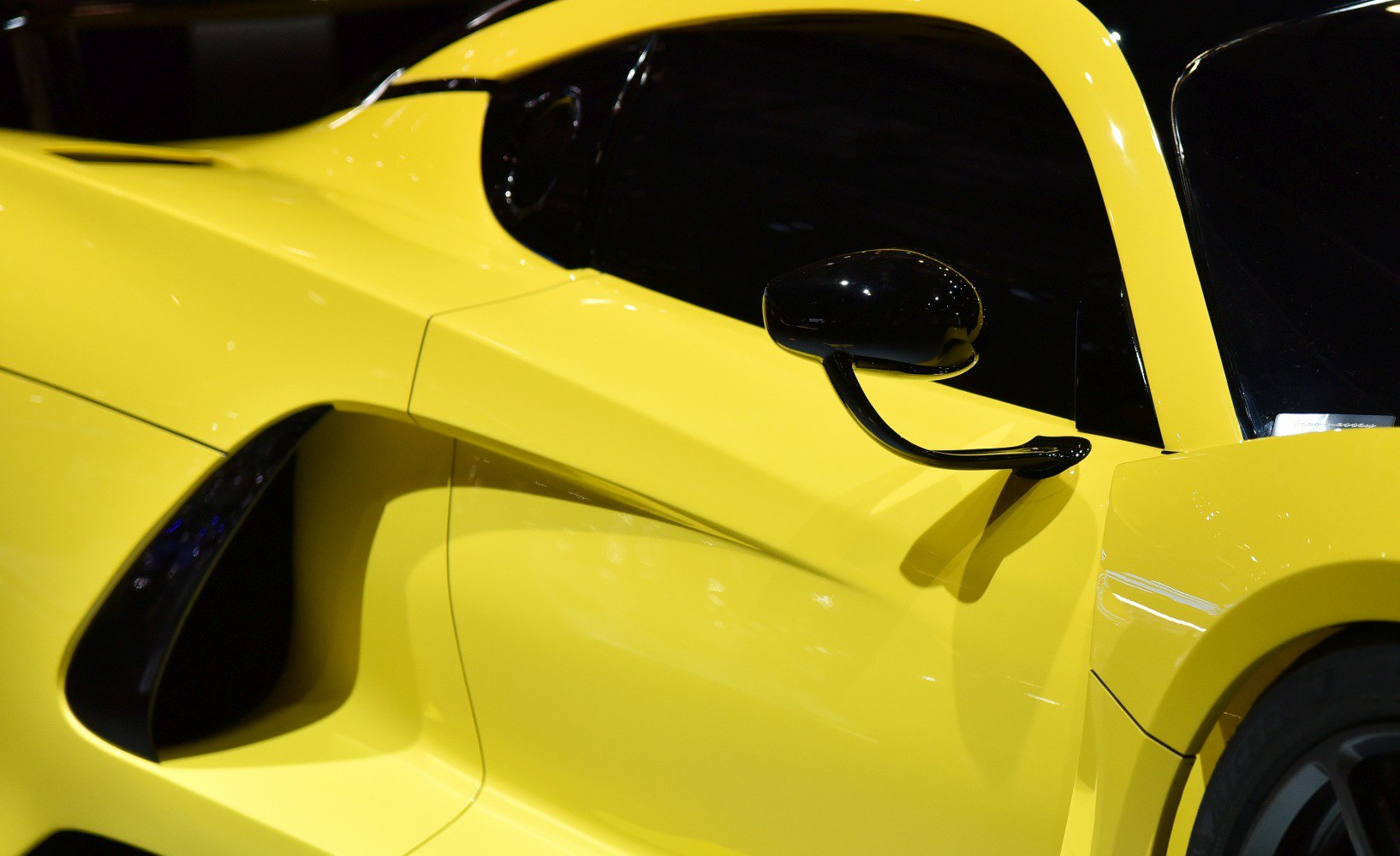 Yellow sports car side air intake and black side mirror