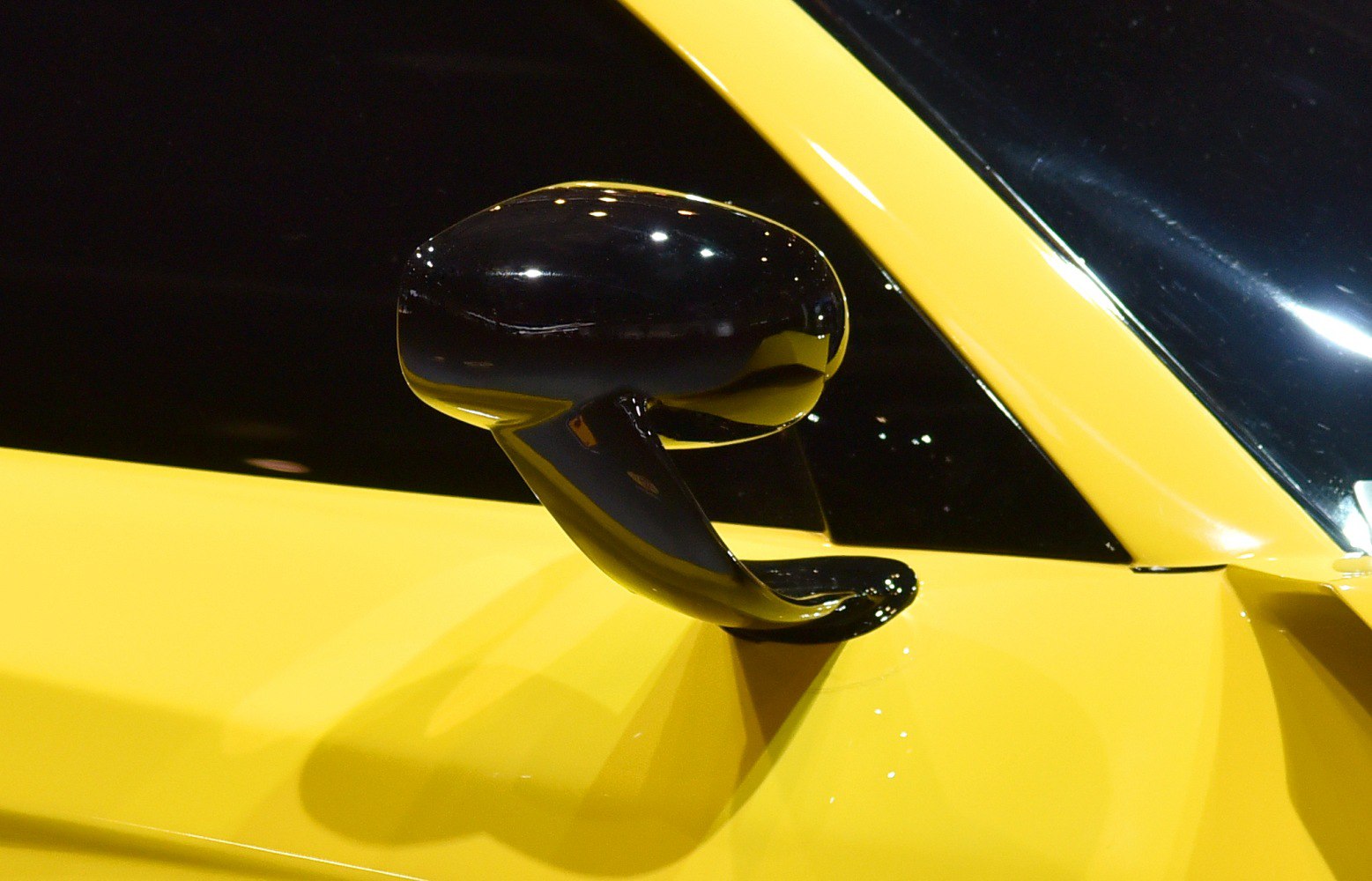 Sleek black aerodynamic side mirror on yellow car door