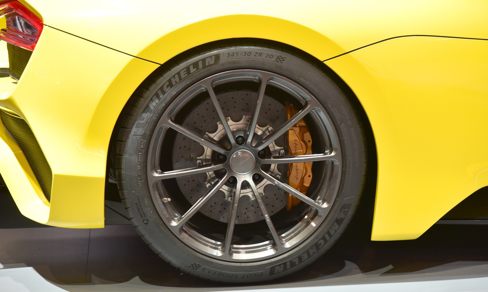 Close-up of a high-performance multi-spoke alloy wheel and carbon ceramic brake disc