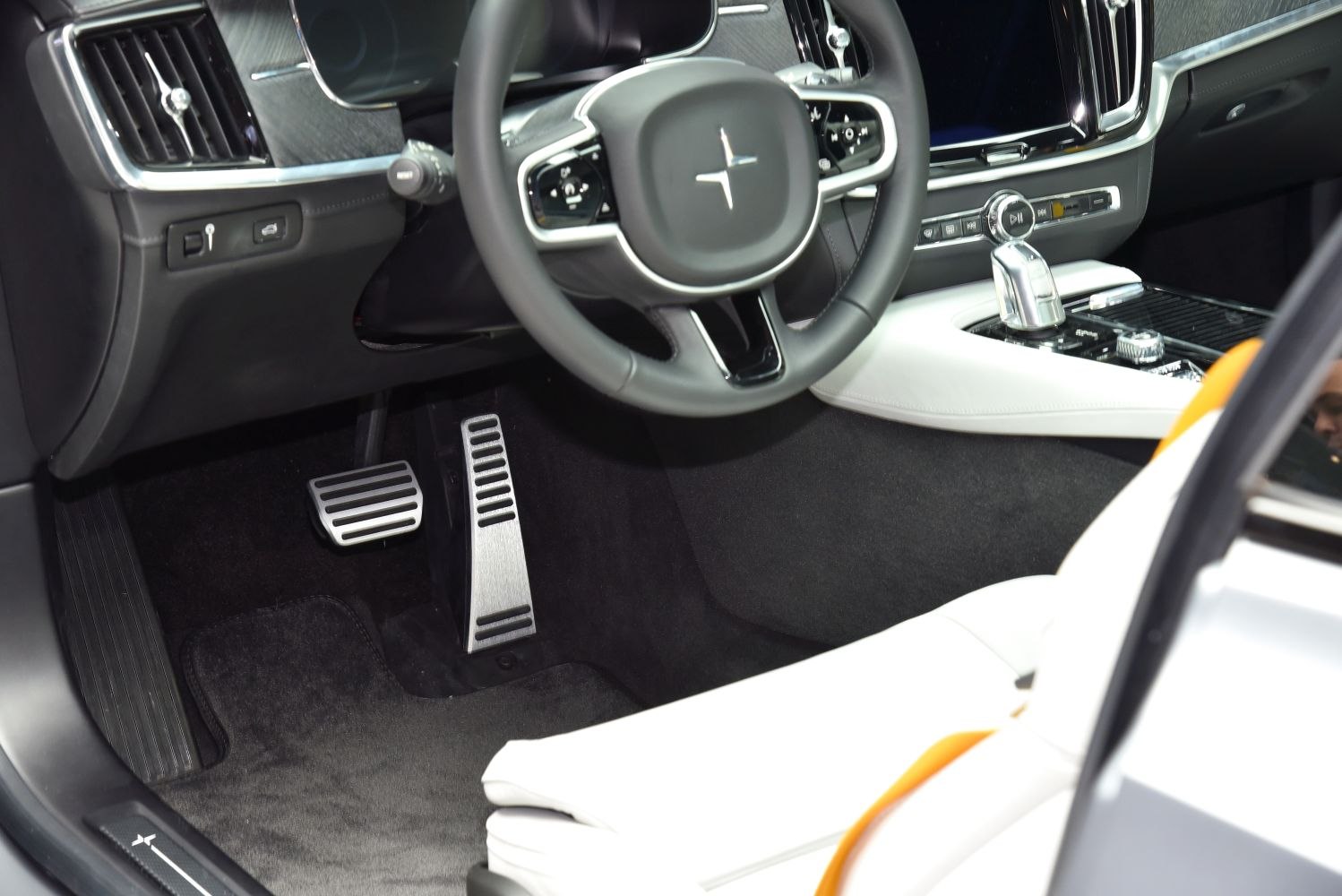 Close-up of steering wheel, pedals, and center console in modern car interior