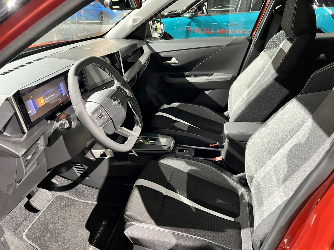 Modern digital dashboard and two-tone front seats with multifunction steering wheel
