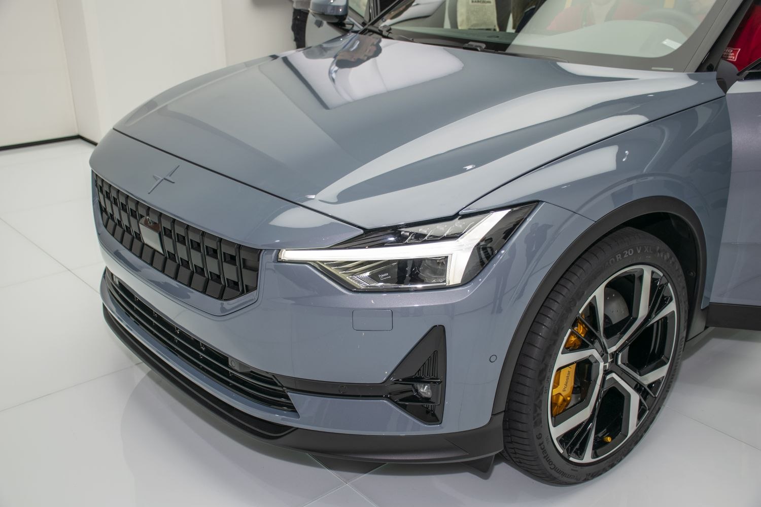 Front headlight, black grille, and alloy wheel with yellow brake calipers
