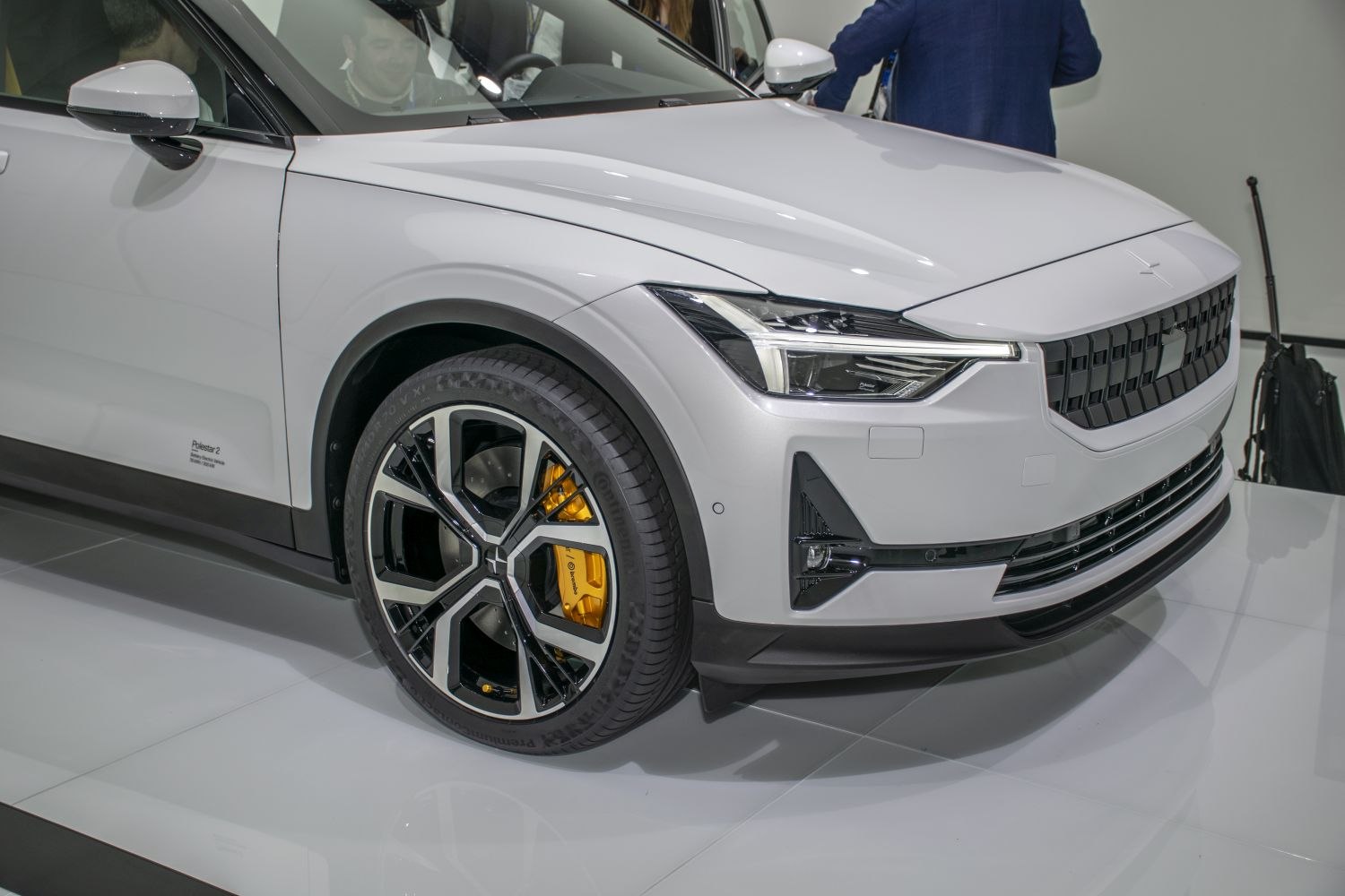 Front wheel, alloy rim, yellow brake caliper, headlight and grille close-up