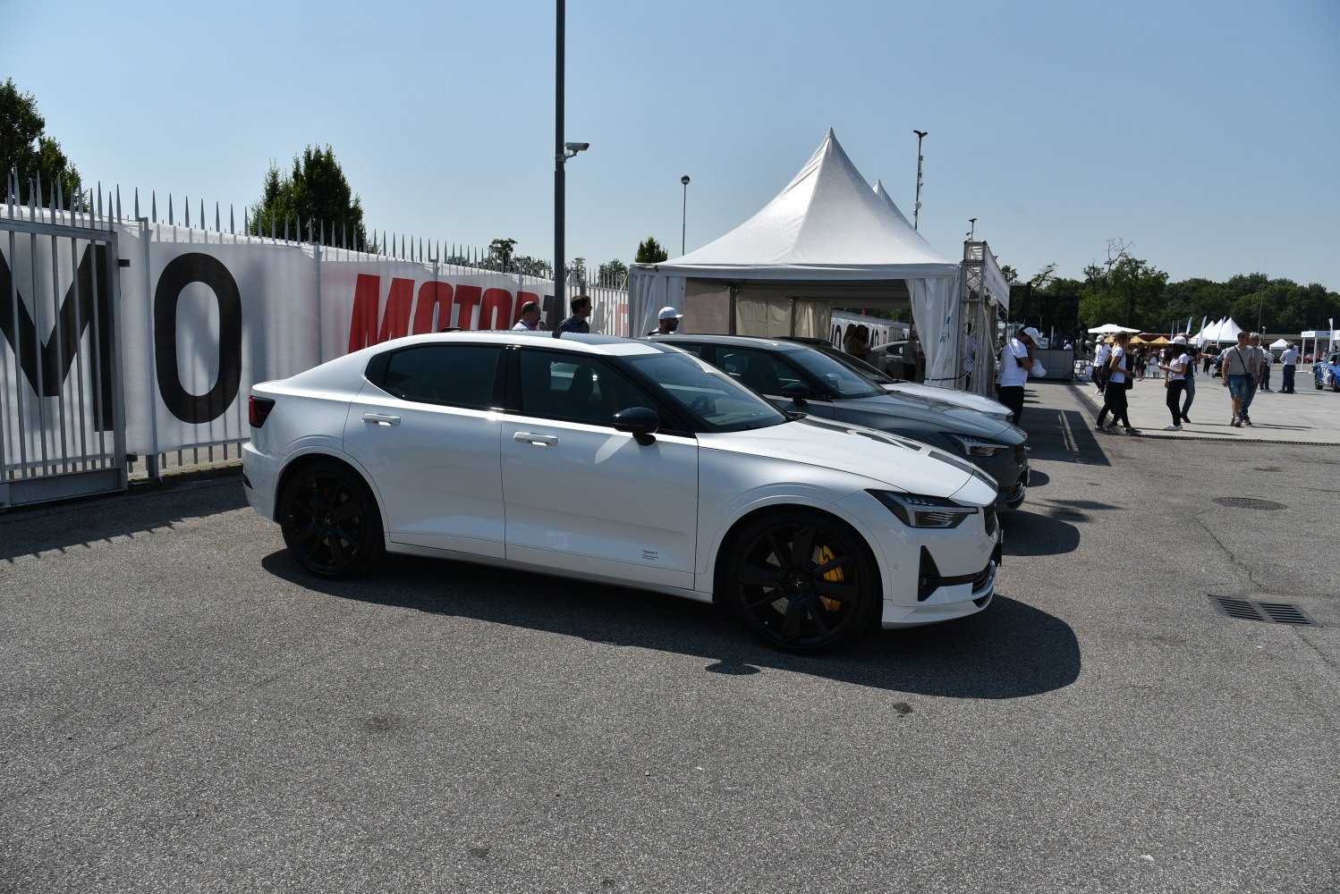 White electric sedan with black wheels and yellow brake calipers