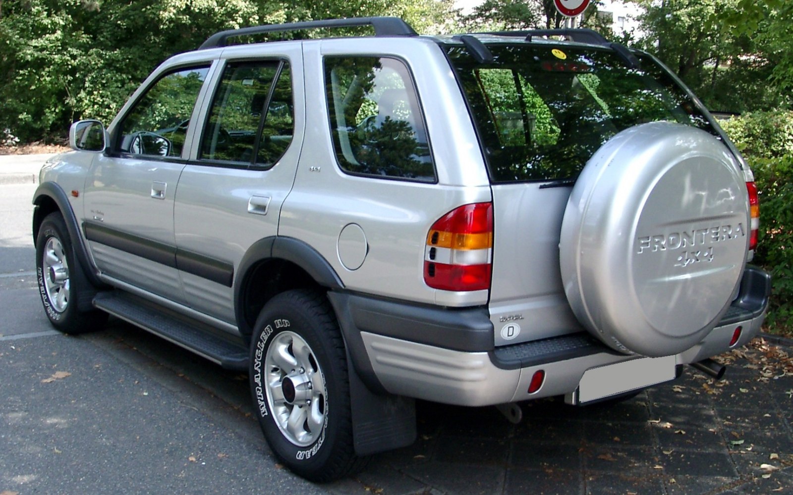 Silver SUV with rear-mounted spare tire and black side trim