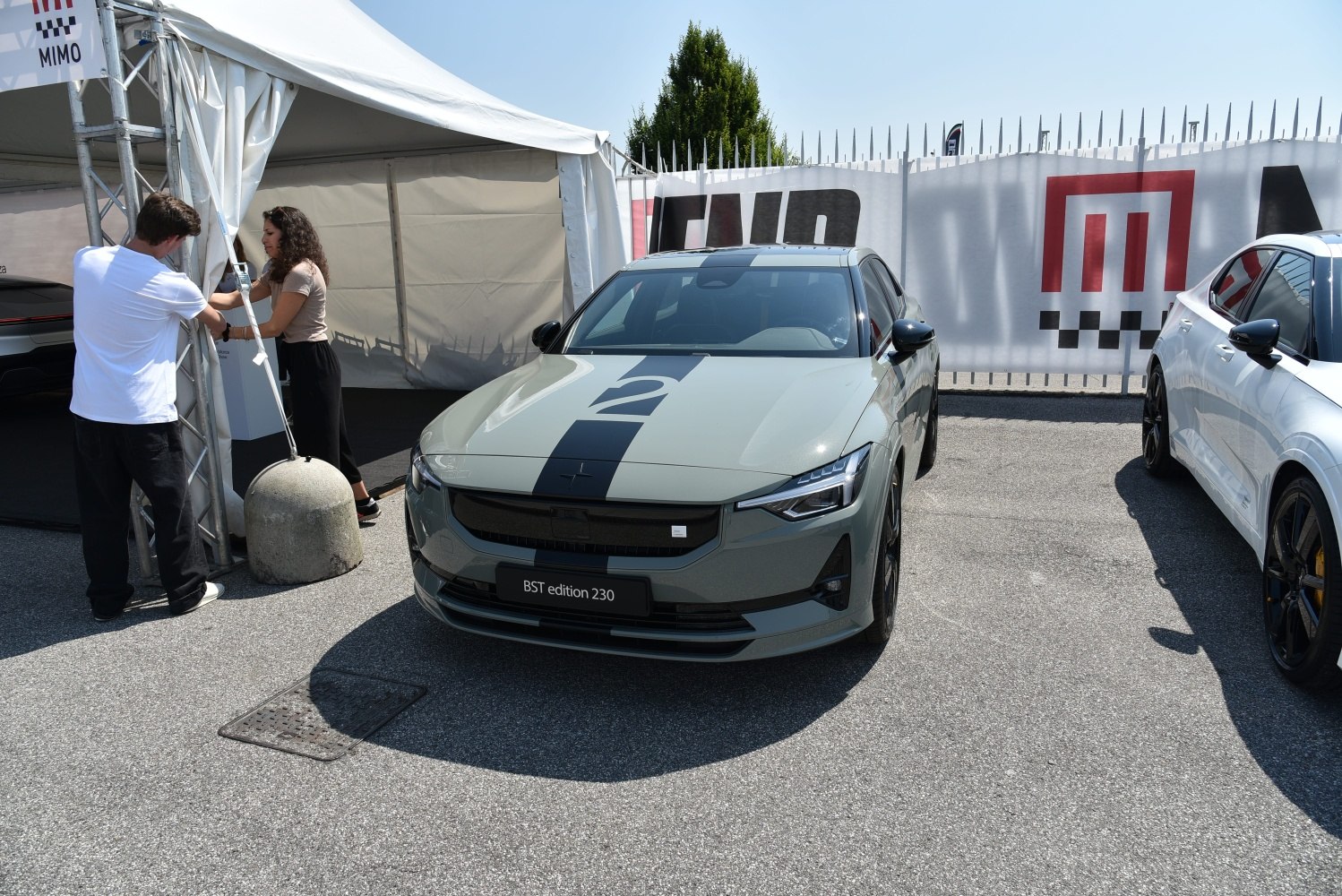 Front view of electric sedan with racing stripe and LED headlights.