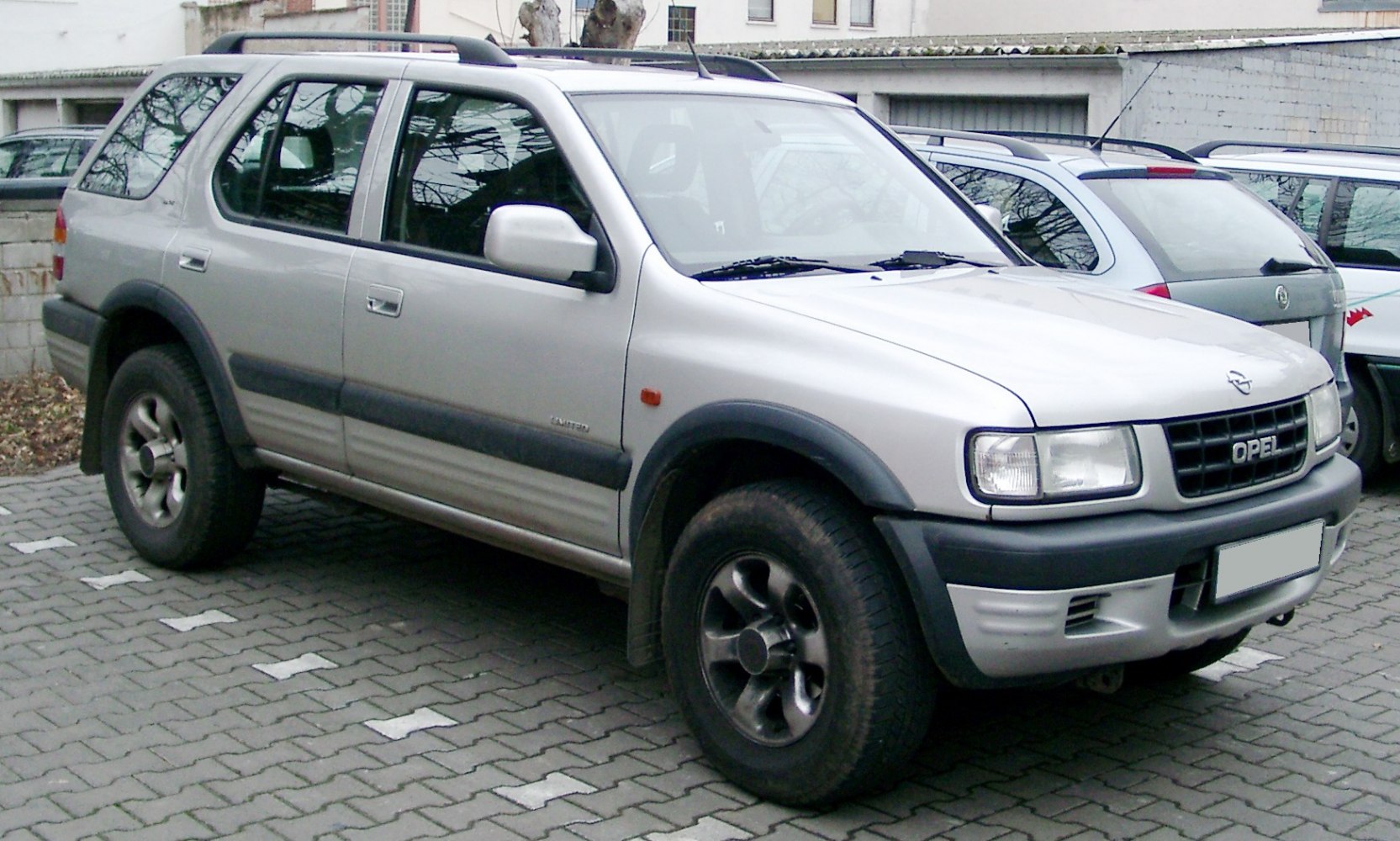 Silver mid-size SUV with off-road tires and roof rails
