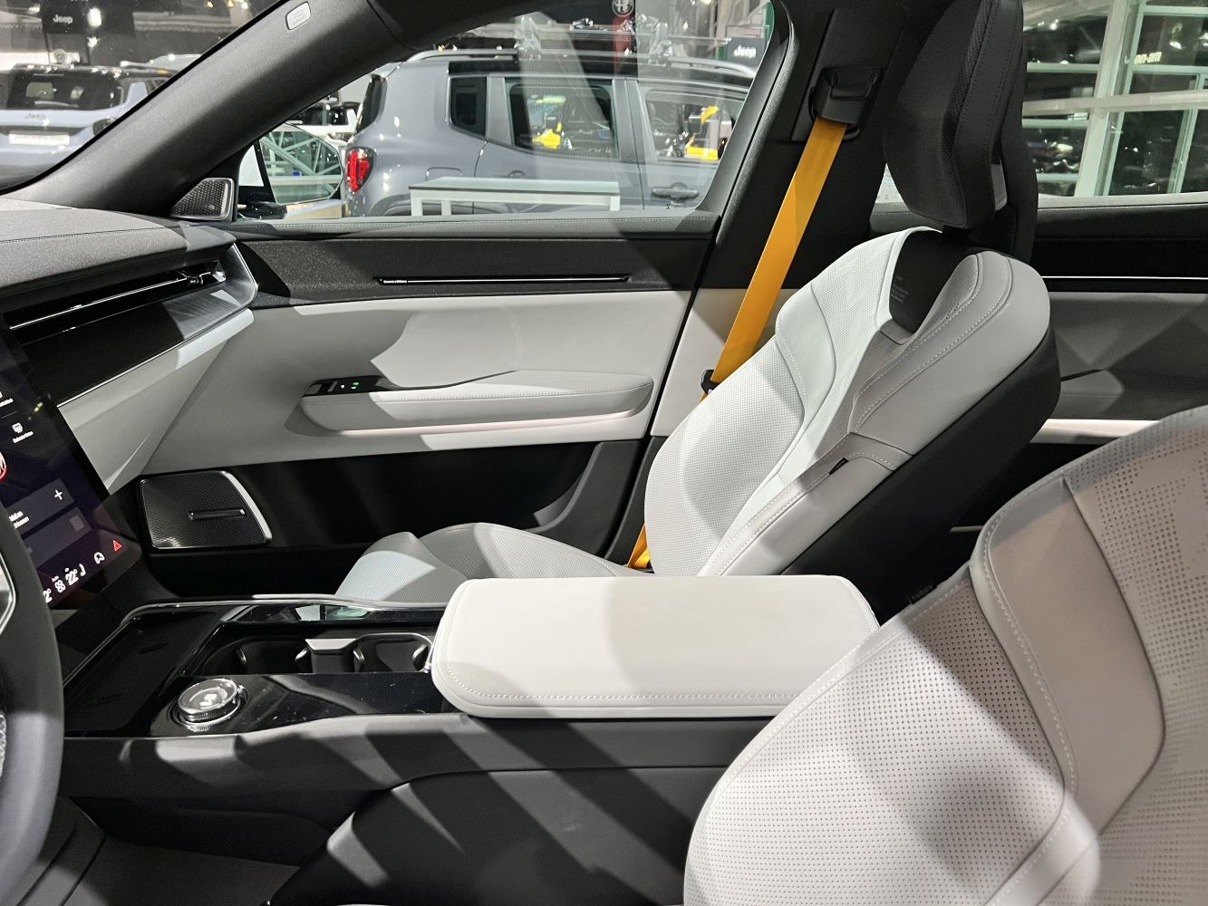 Luxury white leather seats and modern dashboard with yellow seatbelt accent