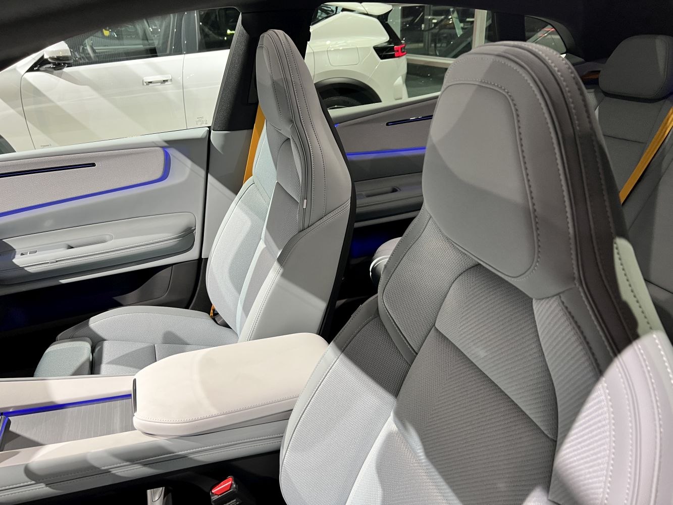 Luxury seats with blue ambient lighting in a modern vehicle interior.
