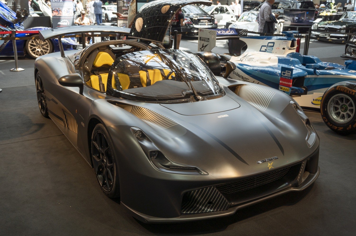 Aerodynamic sports vehicle with prominent rear wing and vivid yellow racing seats