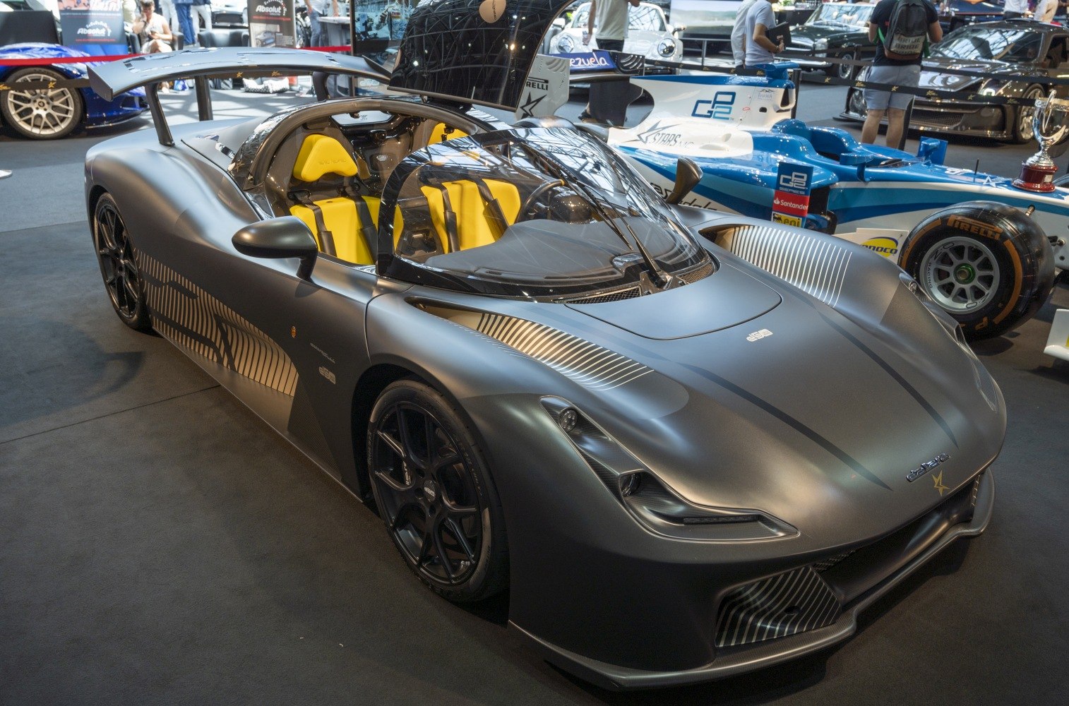 Matte gray aerodynamic sports car with open cockpit and yellow seats