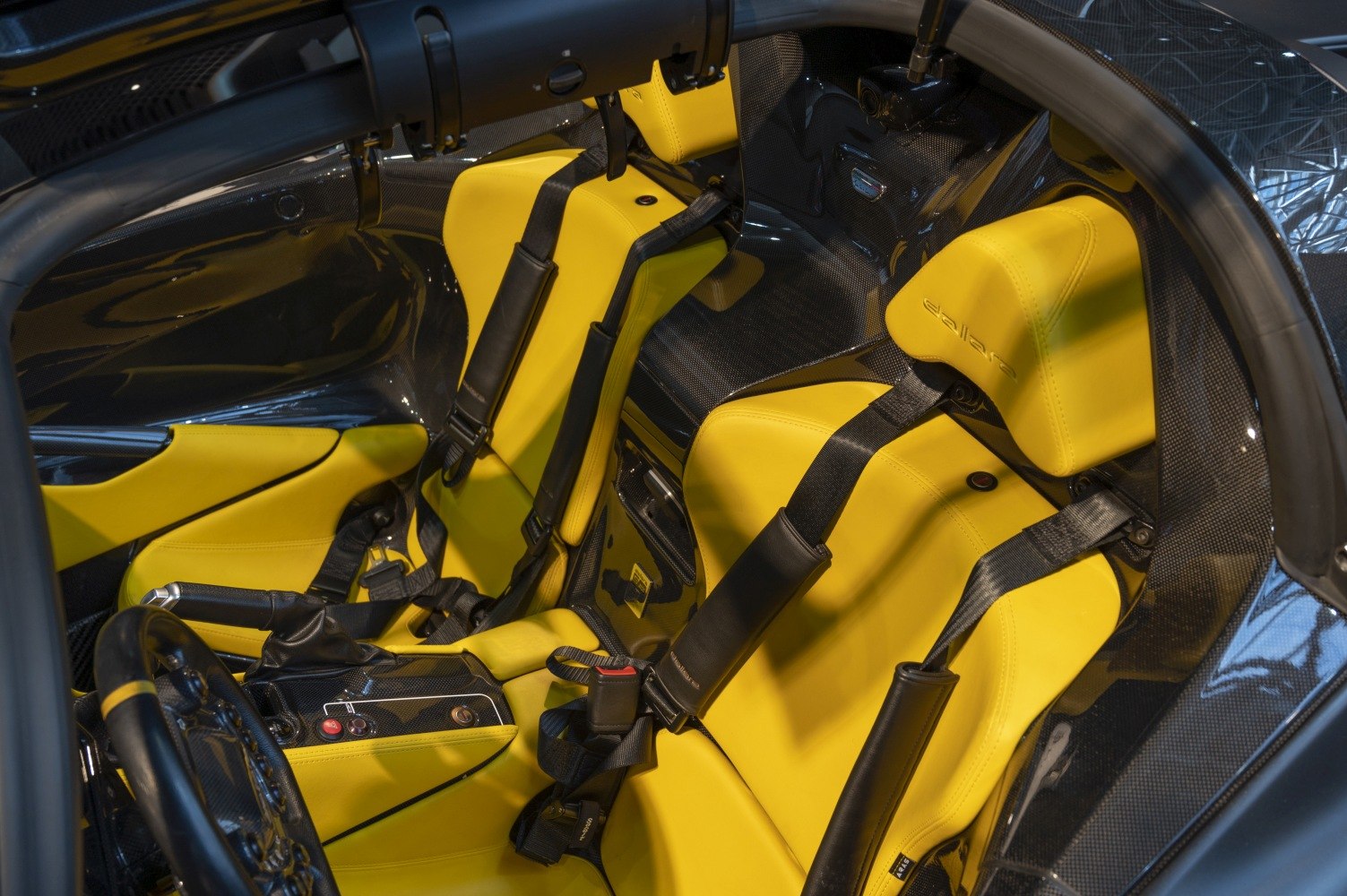 Yellow racing seats with harnesses and carbon fiber detailing
