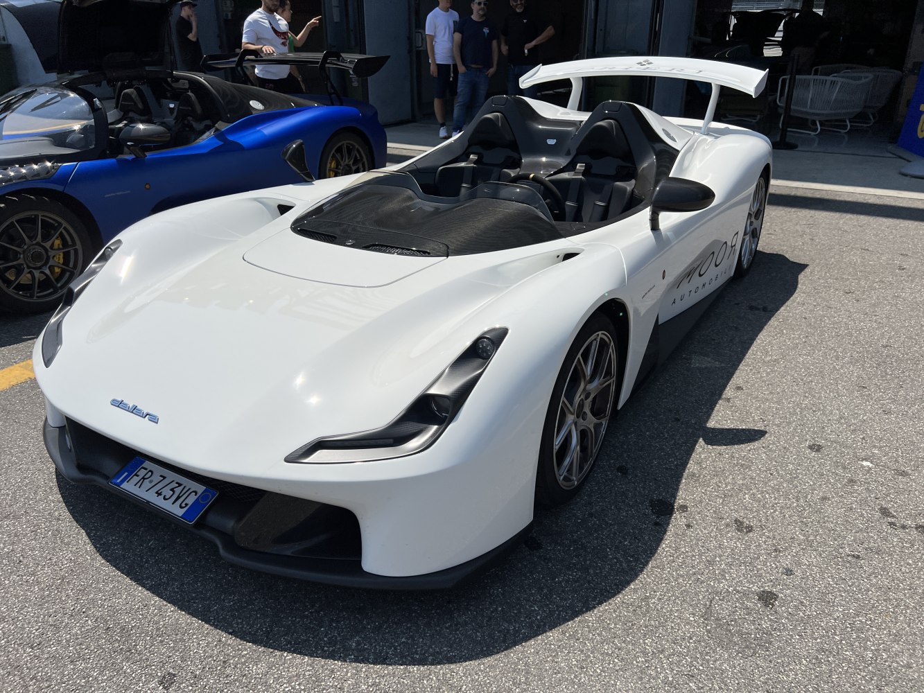 Open cockpit sports car with large rear wing and aerodynamic design