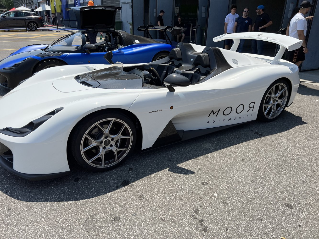 Open-top lightweight sports car with aerodynamic body and rear wing