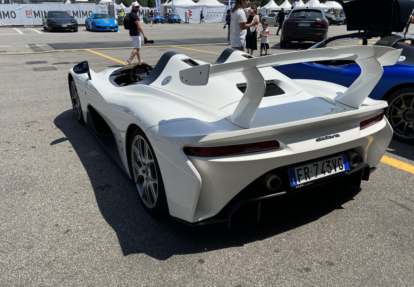 Rear side view featuring large aerodynamic wing and dual exhausts