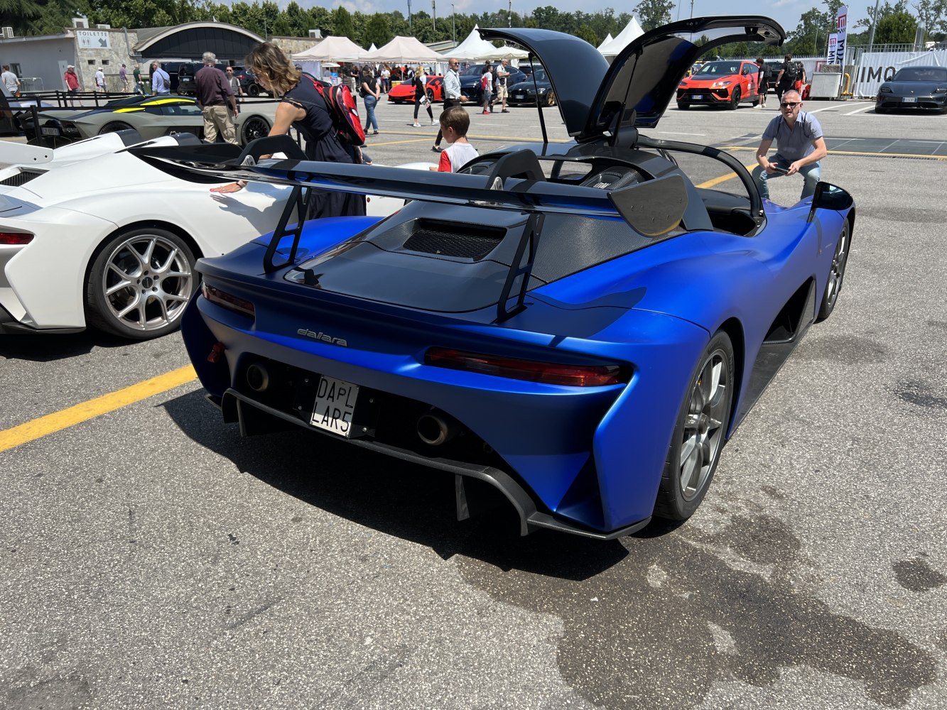 Open-top sports car rear with large rear wing and diffuser.