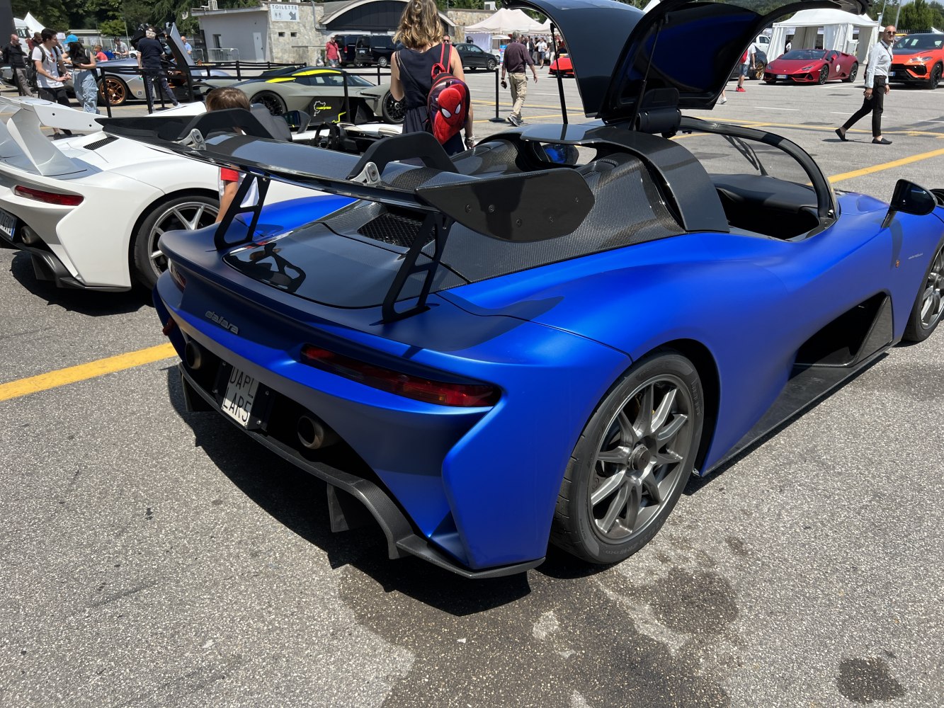 Blue sports car with large rear wing and open cockpit