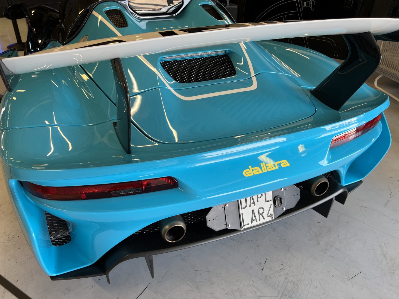 Rear aerodynamic wing and exhaust pipes of a performance sports rear end
