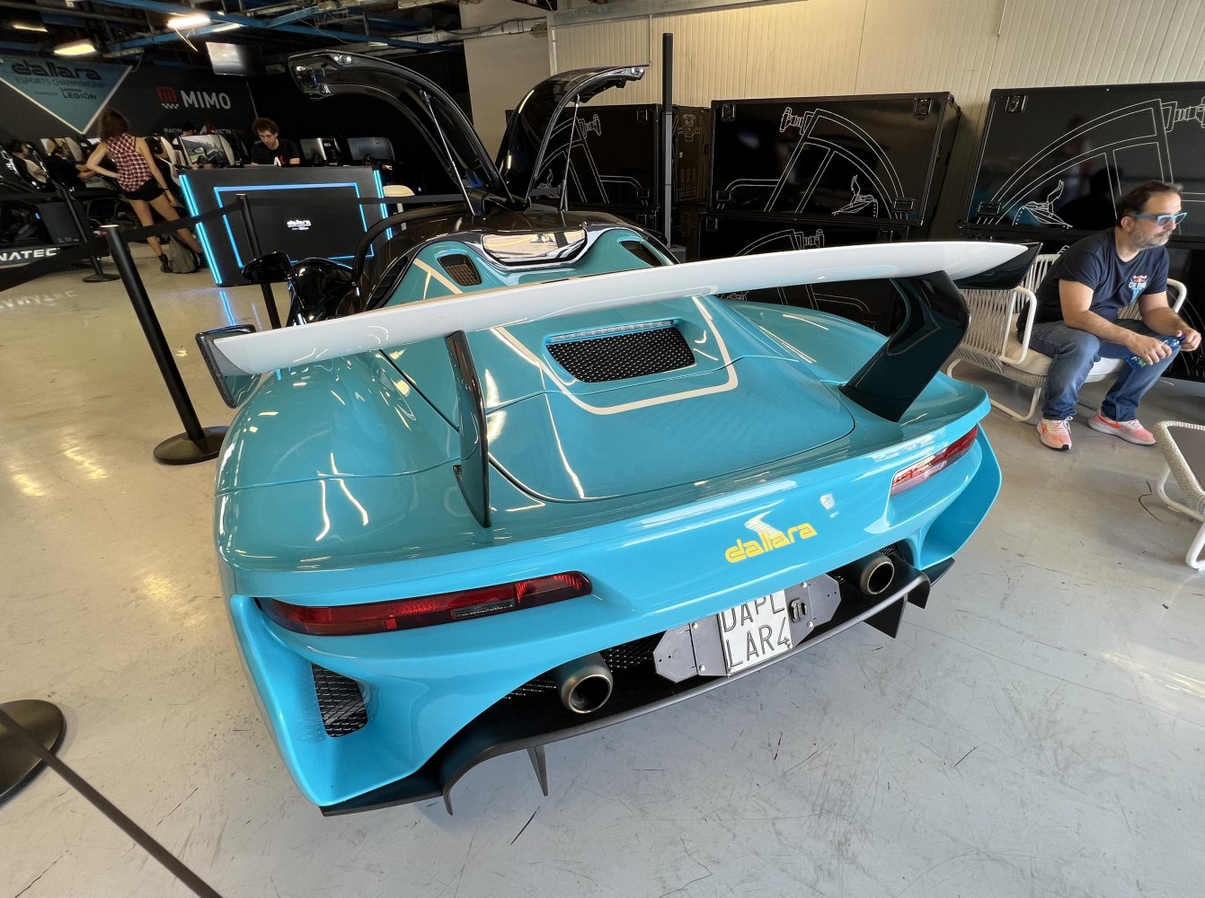 Large rear wing and dual exhausts on blue sports car rear