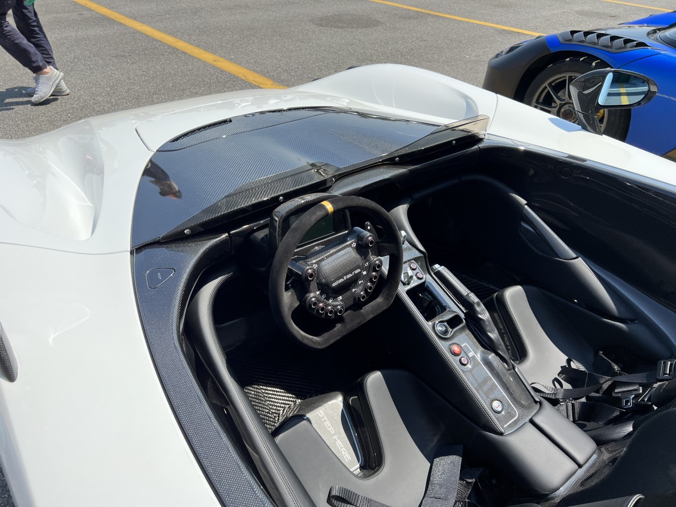 Carbon fiber racing cockpit with minimalist steering wheel and bucket seats