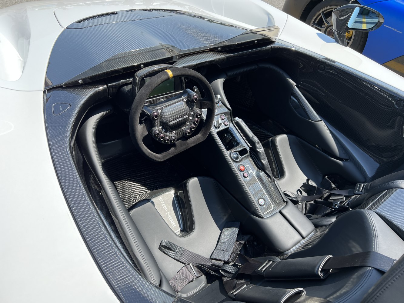 Carbon fiber cockpit with racing steering wheel and harness seats