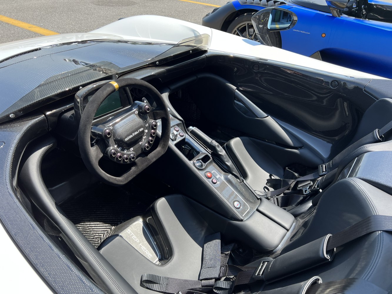 Carbon fiber cockpit with suede racing steering wheel and minimalist racing seats