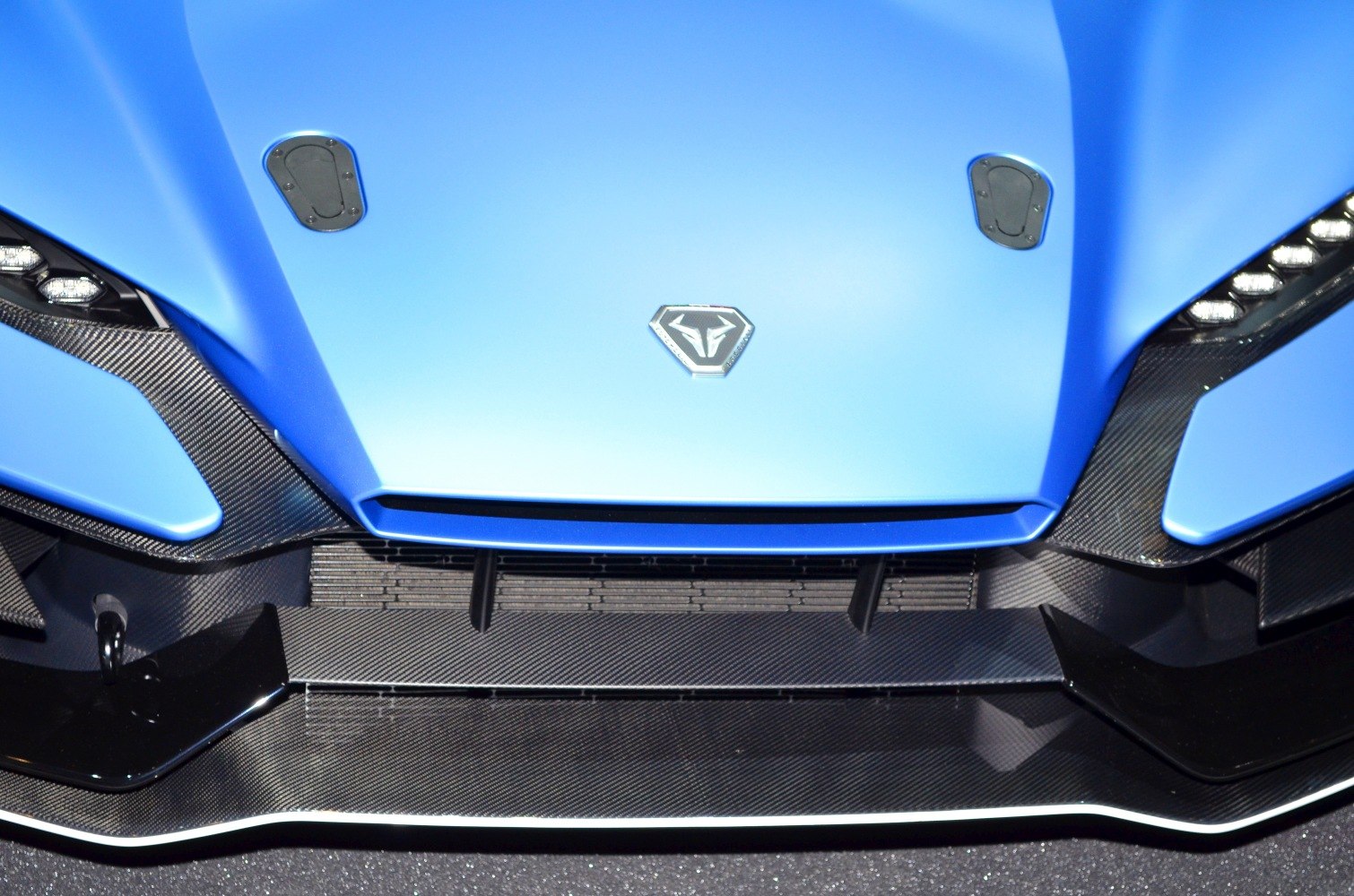 Blue car hood with emblem and carbon fiber front splitter
