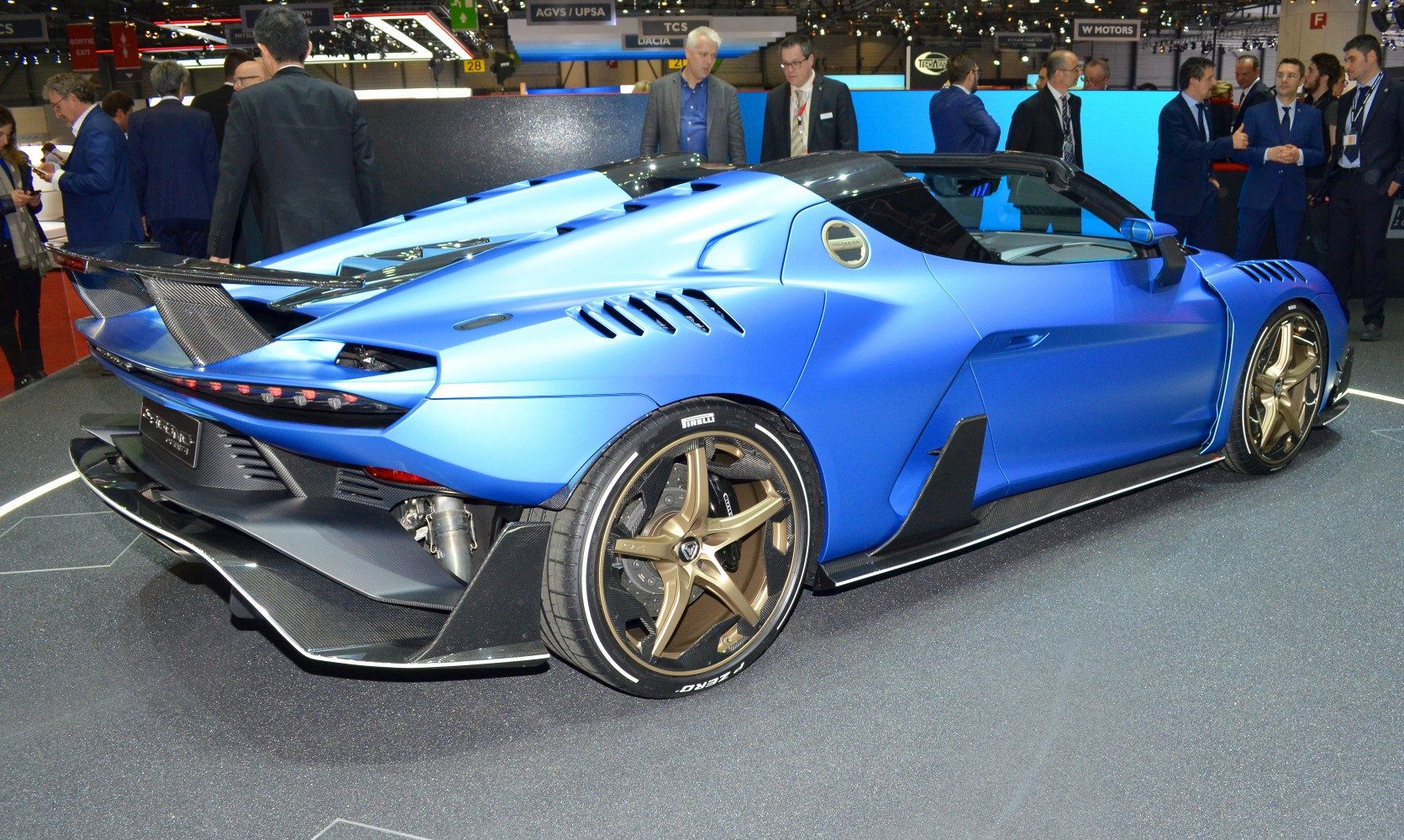 Blue sports car rear side with bronze alloy wheels and carbon fiber spoiler