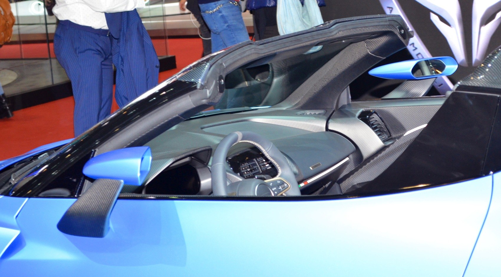 Blue sports car interior with carbon fiber trim and detailed steering wheel
