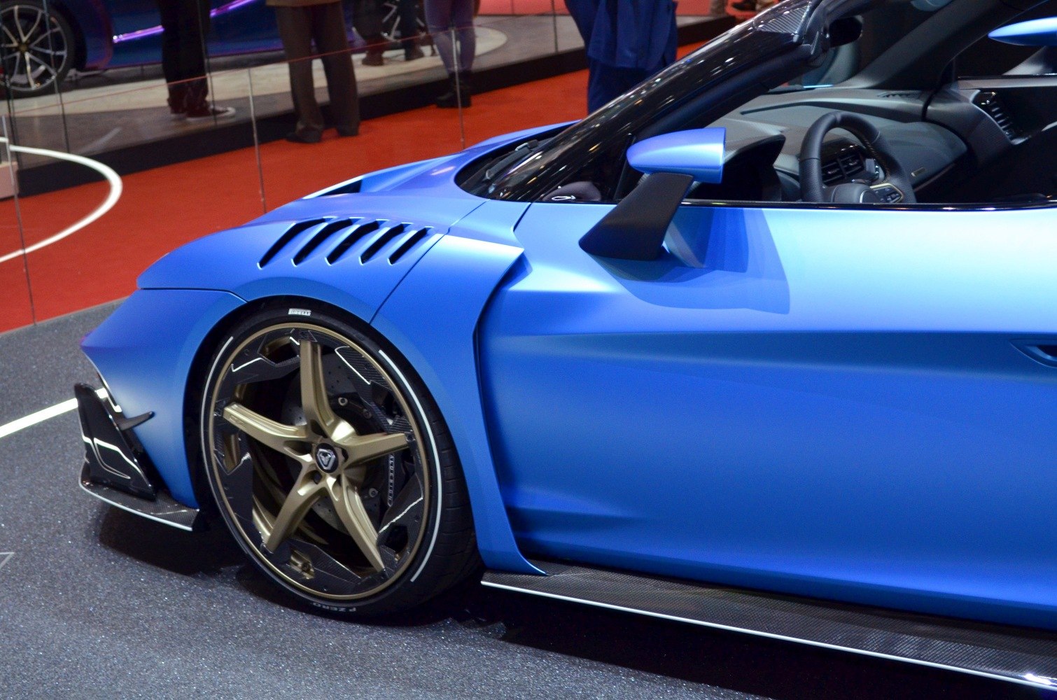 Matte blue side panel with aerodynamic vents and gold alloy wheel