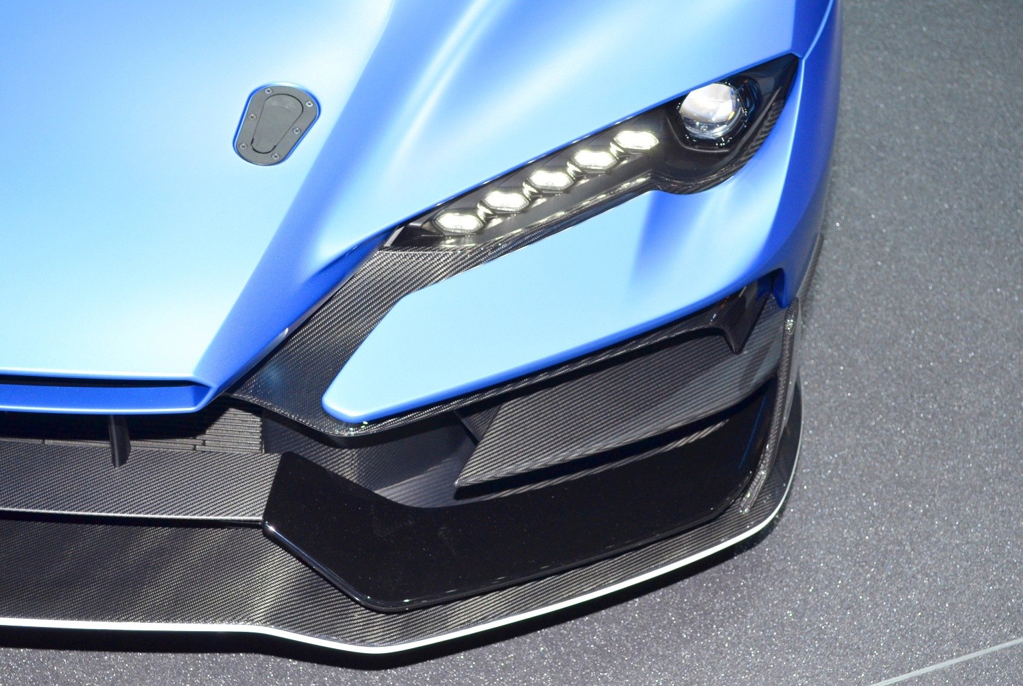 Close-up of front aerodynamic carbon fiber and LED headlight assembly