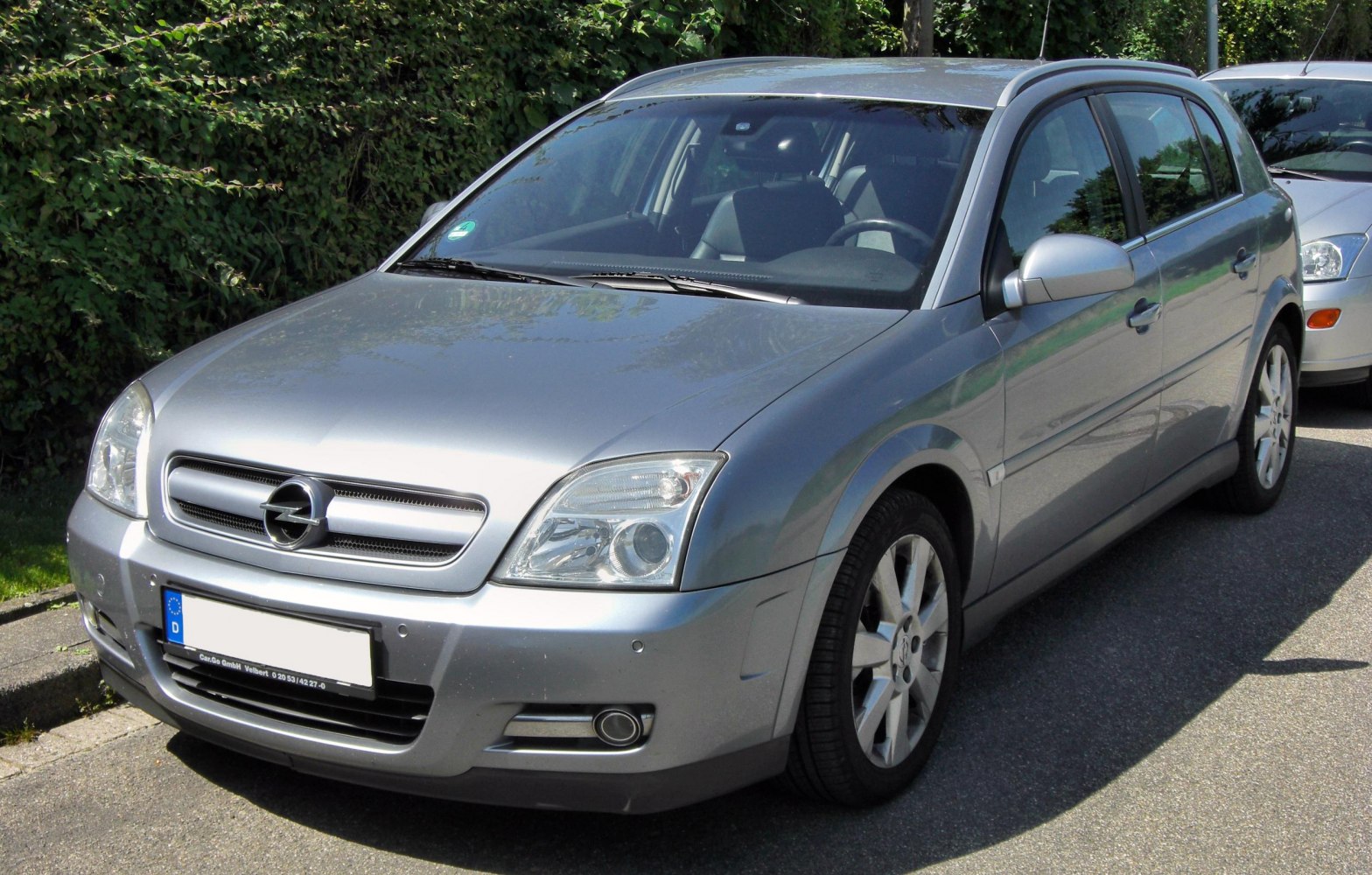 Silver hatchback front-left angle with headlights and grille.