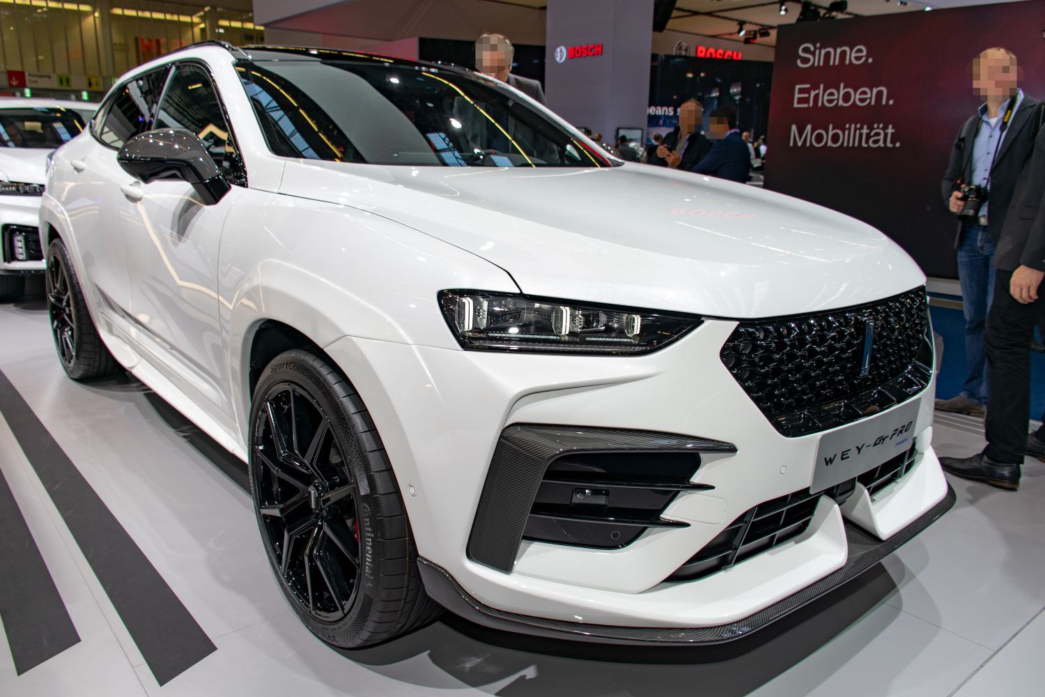 Front view of sporty SUV with aggressive grille and black wheels