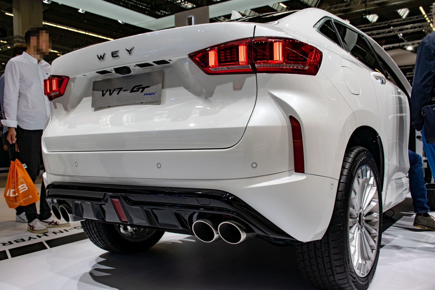 Rear of a white SUV with LED tail lights and quad exhaust pipes