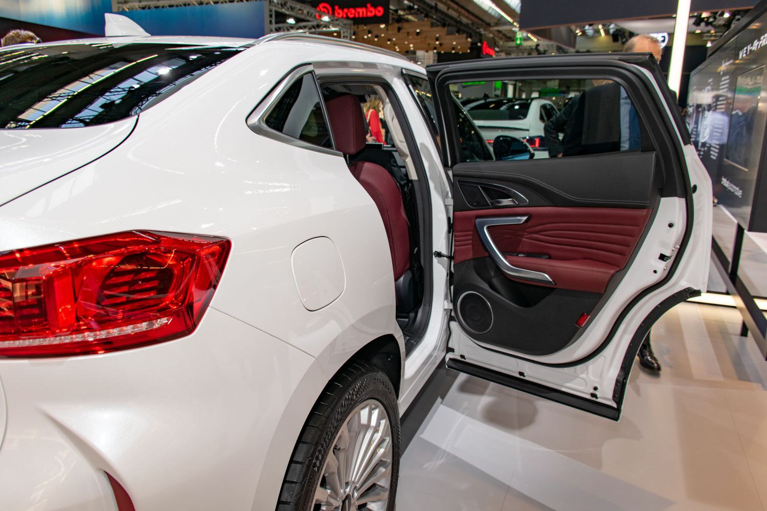 Rear door open with red leather interior and detailed door panel.
