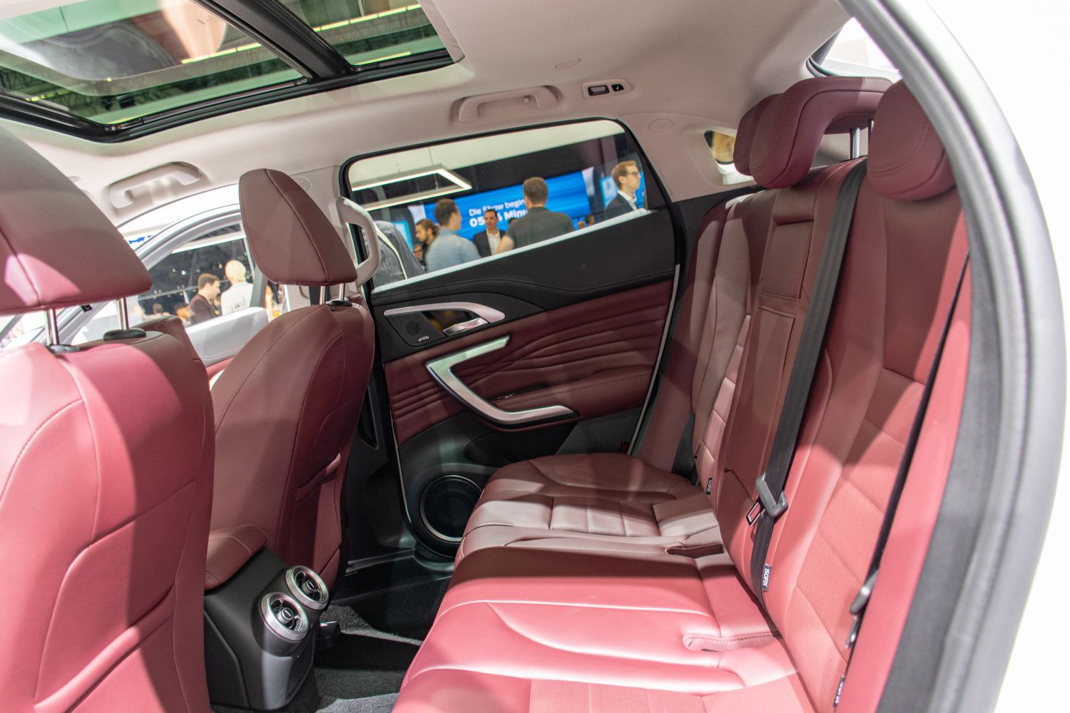 Red leather rear seats with panoramic sunroof and modern door panel.