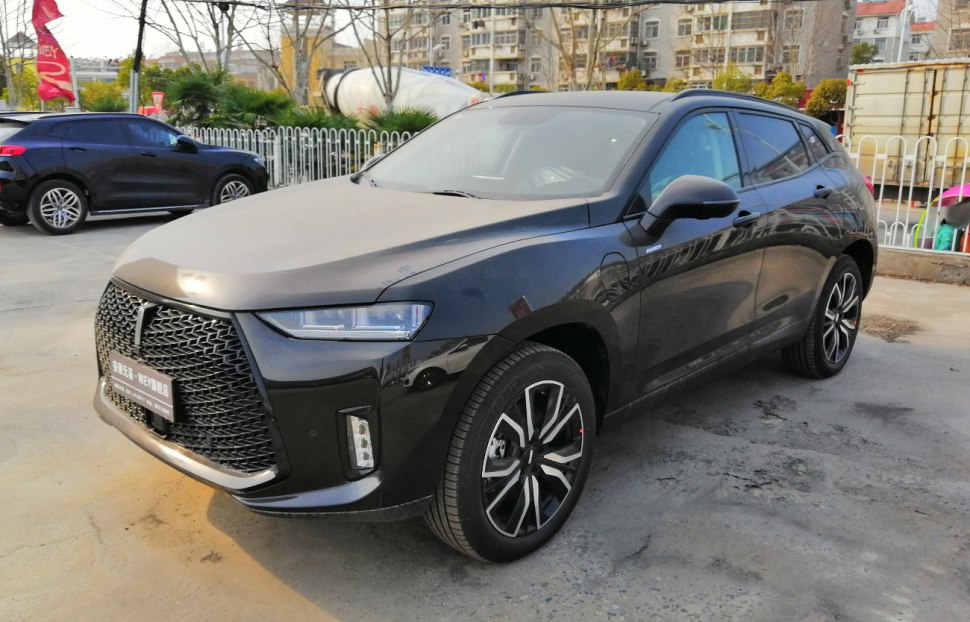 Front exterior of a dark SUV with LED headlights and large black grille.