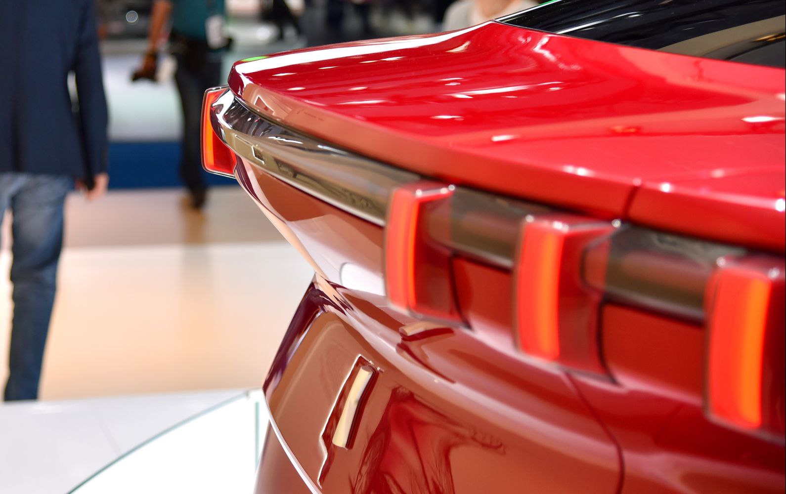 Close-up of futuristic rear LED taillights and glossy red rear body