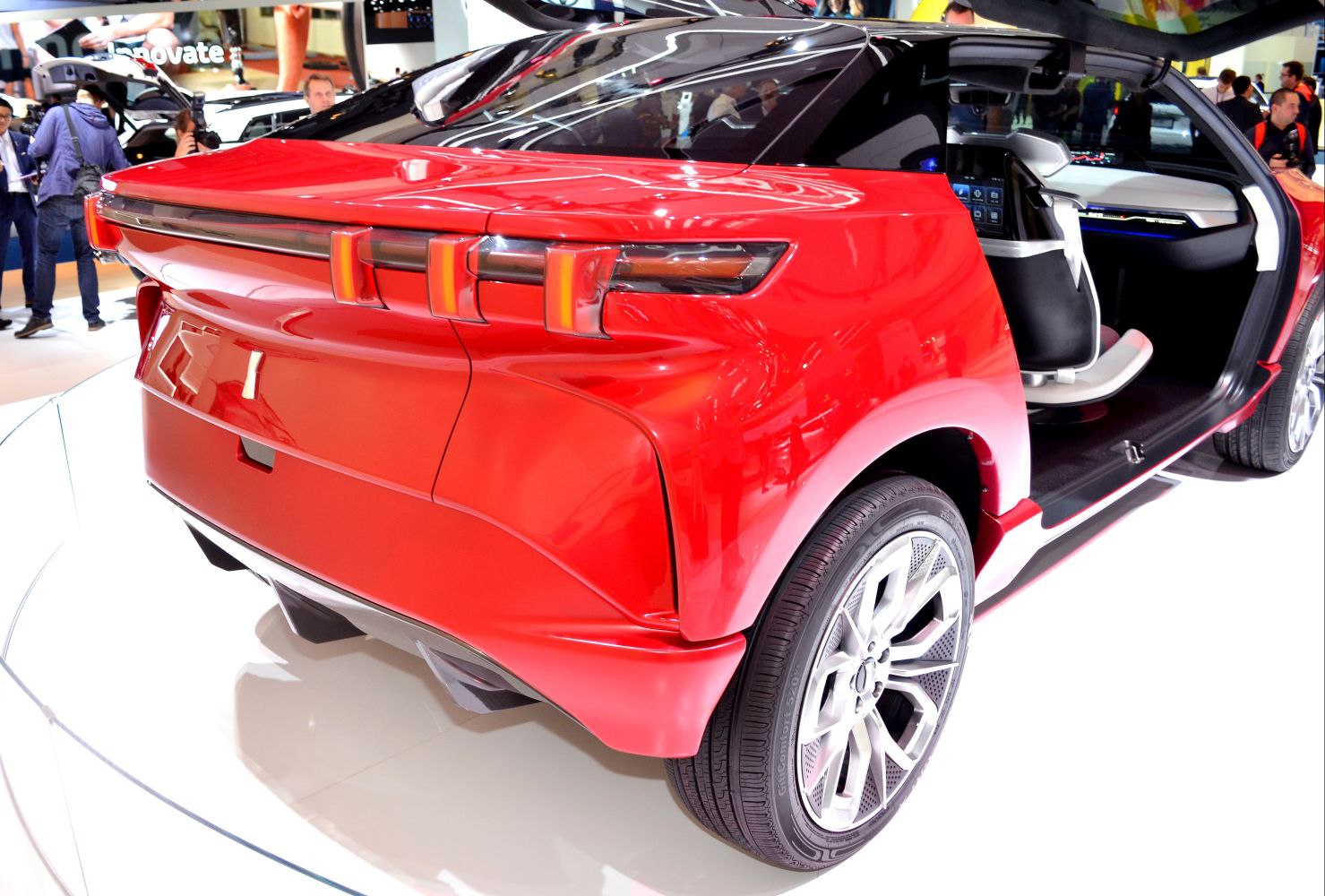 Futuristic rear design and open-door interior of a red SUV concept.