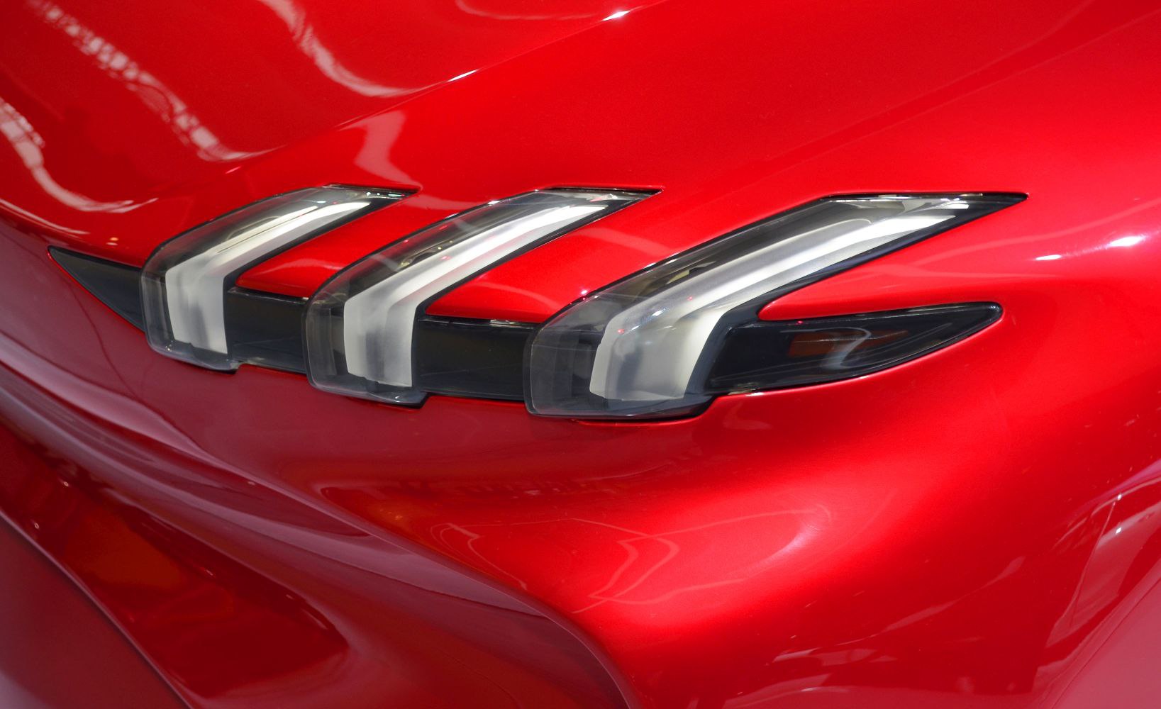 Triple LED headlights with sleek front grille on red body