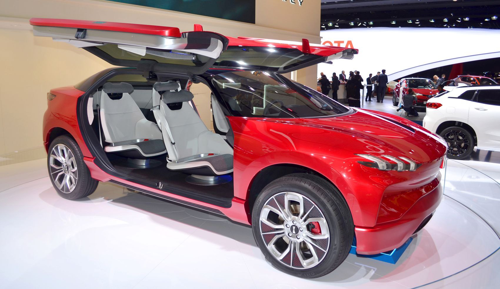 Red futuristic vehicle with gullwing doors and minimalist interior seating