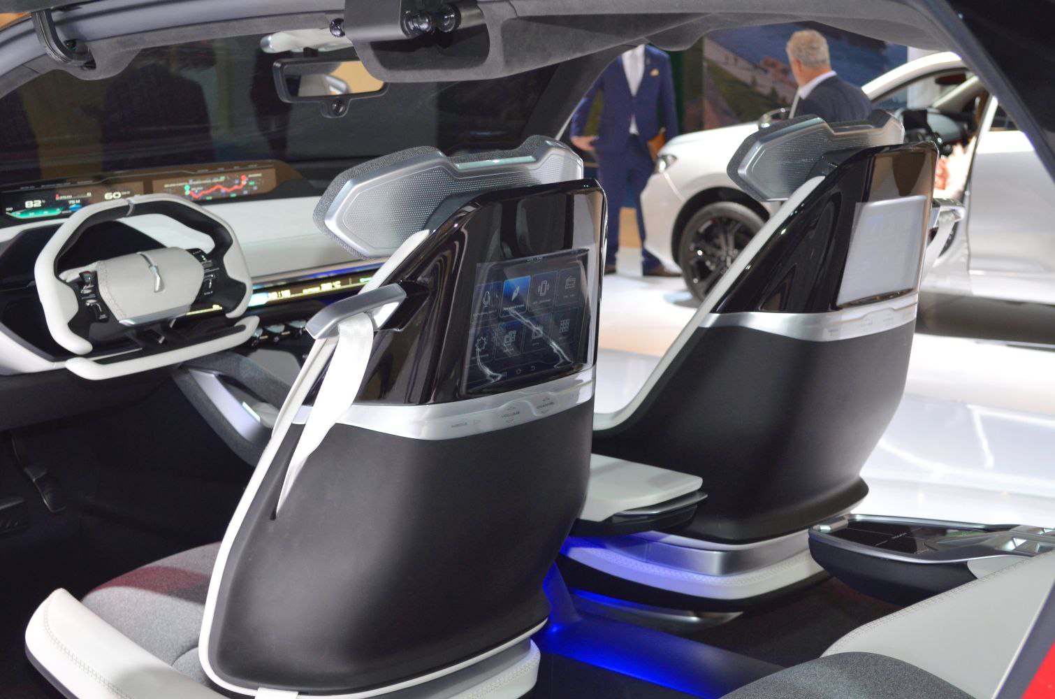 Futuristic car interior with digital dashboard and touchscreens on seat backs