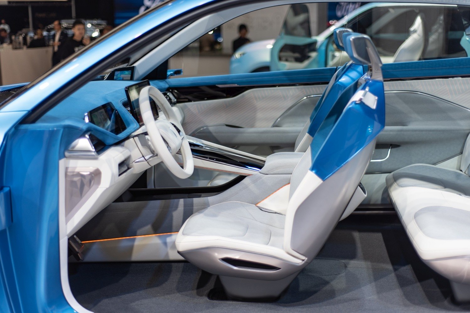 Futuristic blue and white seats with digital dashboard inside a concept vehicle