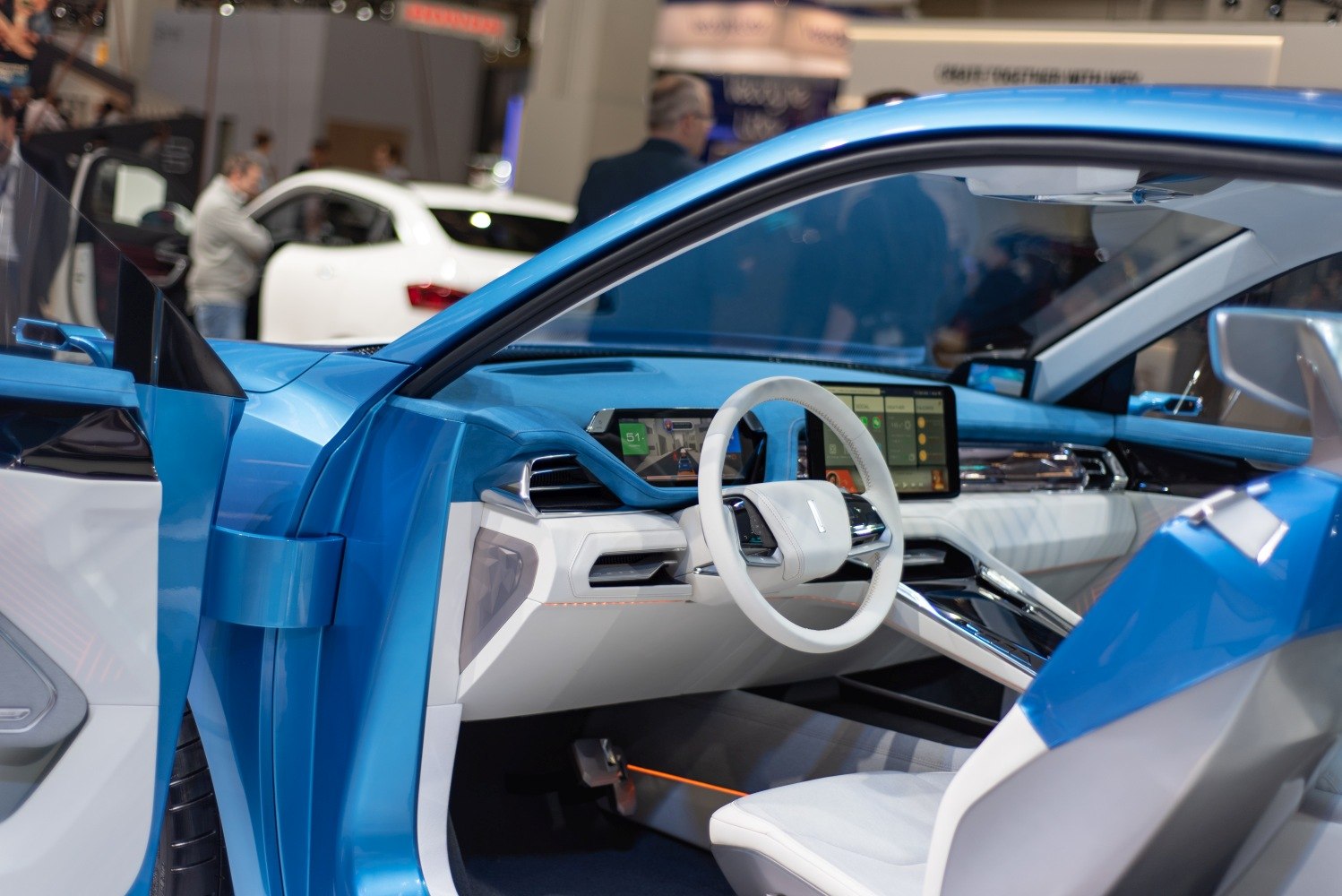White steering wheel and dual digital displays in blue and white interior