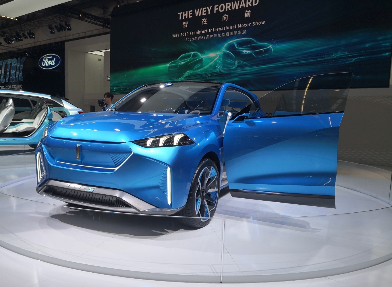 Futuristic blue electric SUV with scissor doors and sleek design